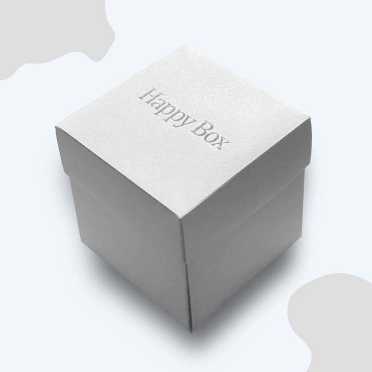 Weisse Happy Box Geschenkverpackung mit eleganter Praegung auf dem Deckel.