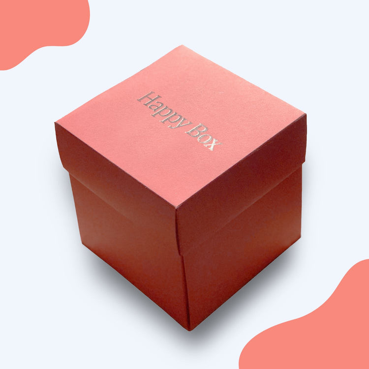 Korallfarbene Happy Box Geschenkbox mit silberner Praegung auf dem Deckel, ideal zum Befuellen.