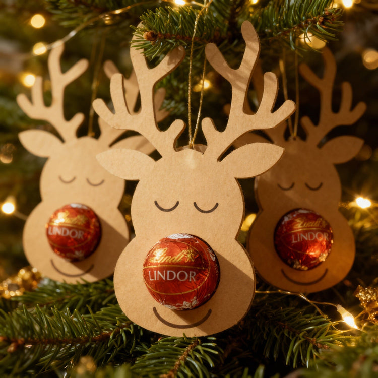 Rentier-Schokoladenhalter aus Kraftpapier mit Lindt Lindor Kugel als Nase am Weihnachtsbaum haengend.