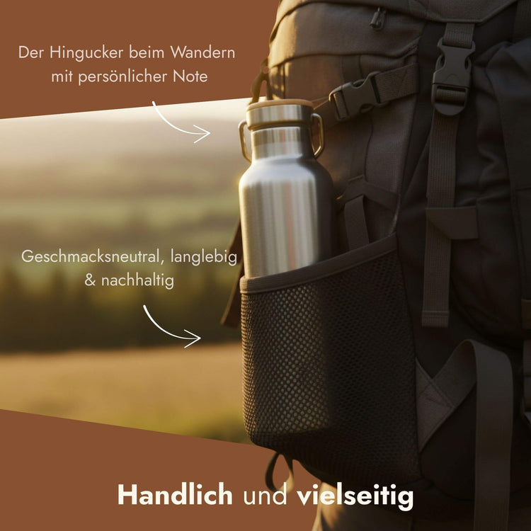 Personalisierbare Edelstahl-Trinkflasche griffbereit in der Netztasche eines Wanderrucksacks.