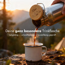 Personalisierte Edelstahl-Trinkflasche mit Namensgravur Elias und Bergmotiv auf Holzdeckel beim Outdoor-Einsatz.