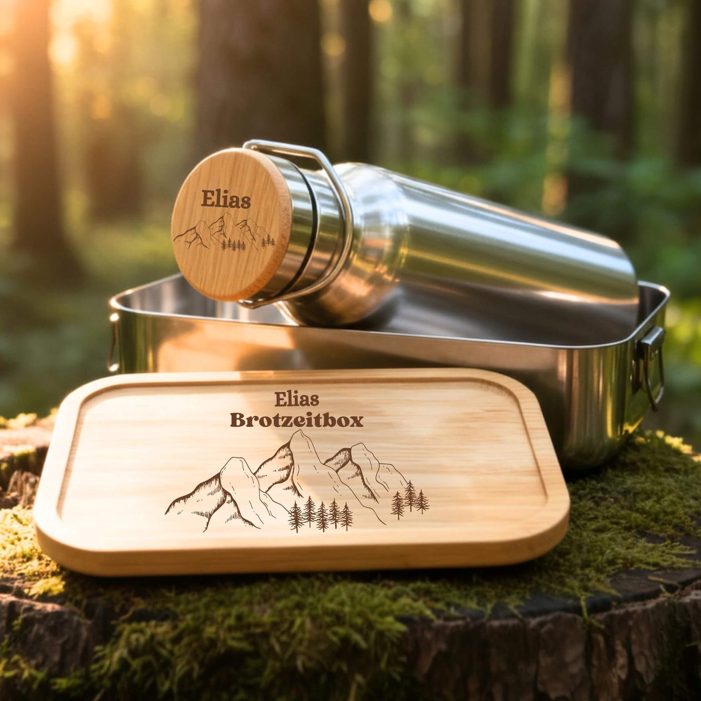 Personalisiertes Edelstahl Trinkflaschen und Brotzeitbox Set mit Bambusdeckel, Namensgravur Elias und Berg-Waldmotiv.