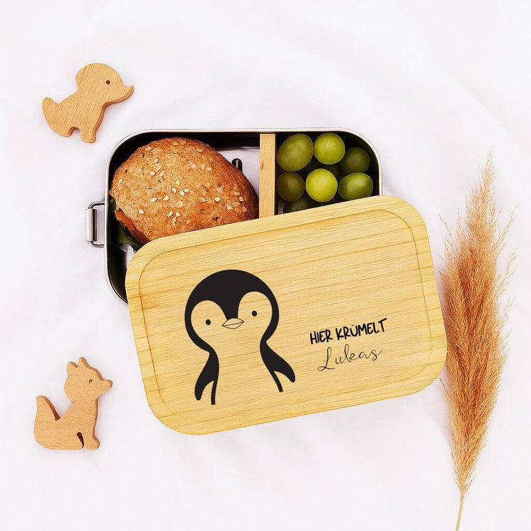 Personalisierte Edelstahl-Brotdose mit Bambusdeckel, Pinguin-Motiv und graviertem Namen Lukas fuer Kinder.