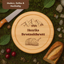 Rundes Brotzeitbrett aus Buche mit personalisierter Gravur, Bergmotiv und Namensgravur als Geschenkidee.