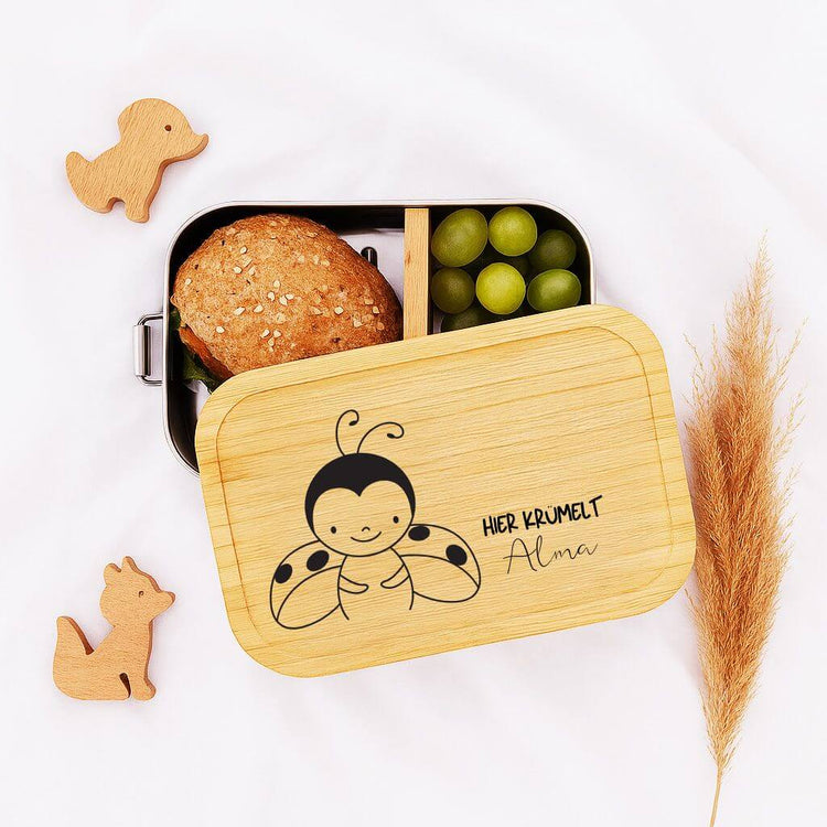 Personalisierte Edelstahl-Brotdose mit Bambusdeckel, Marienkaefer-Gravur und Name Alma fuer Kinder.