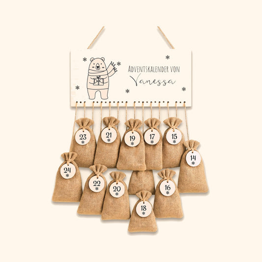 Personalisierter Adventskalender mit Jutesaeckchen und Namensschild vor cremefarbenem Hintergrund.