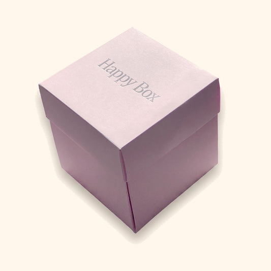 Happy Box – Geschenkbox in 6 Varianten vor cremefarbenem Hintergrund.