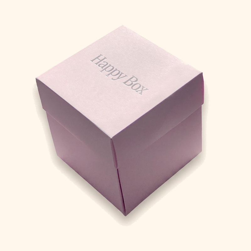 Happy Box – Geschenkbox in 6 Varianten vor cremefarbenem Hintergrund.