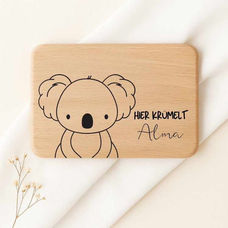 Personalisiertes Frühstücksbrettchen aus Buchenholz mit Koala-Motiv und graviertem Namen Alma.