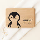 Personalisiertes Frühstücksbrettchen aus Buche mit Pinguin-Motiv und Gravur Hier krümelt Alma.