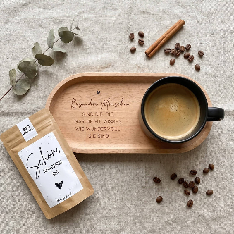 Geschenkset Kaffeepause von oben auf Leinen: Tasse mit Gravur auf dem Buchentablett, Tütchen, Kaffeebohnen, Zimtstange und Eukalyptus.