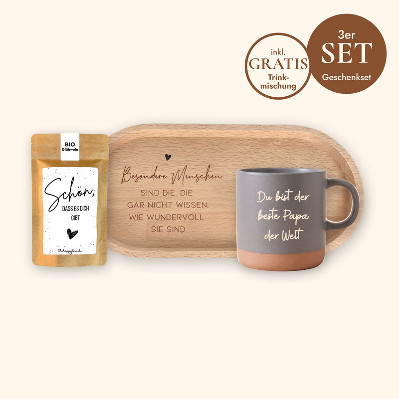 Geschenkset Kaffeepause: Keramiktasse Grau mit Wunschtext-Gravur, ovales Holz-Tablett aus Buche mit Spruch und Sprüche-Tütchen „Schön, dass es dich gibt“ vor cremefarbenem Hintergrund.