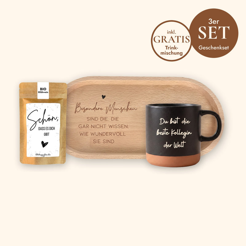 Geschenkset Kaffeepause: Keramiktasse Schwarz mit Wunschtext-Gravur, ovales Holz-Tablett aus Buche mit Spruch und Sprüche-Tütchen „Schön, dass es dich gibt“ vor cremefarbenem Hintergrund.