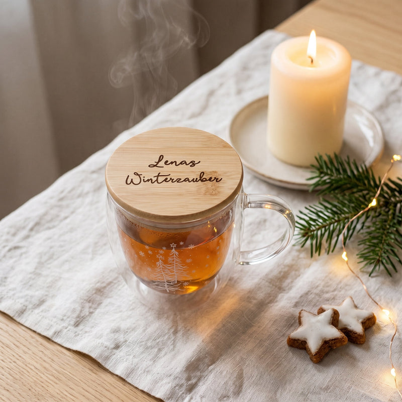 Doppelwandiger Glasbecher mit Tannenbaum-Dekor und graviertem Bambusdeckel „Lenas Winterzauber“, mit Tee und Kerze