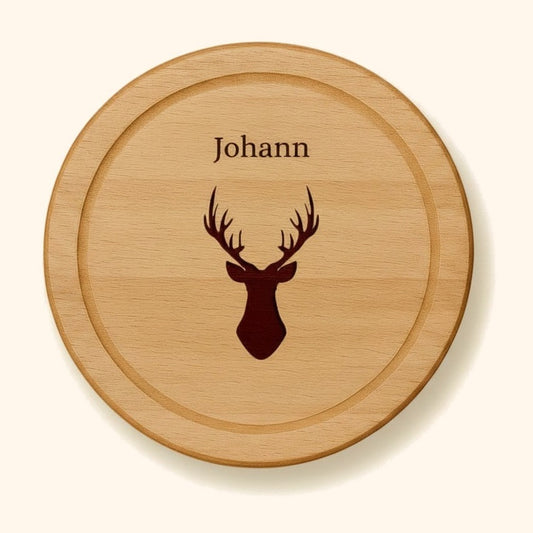 holzbrett personalisiert buche rund 25cm hirsch vor cremefarbenem Hintergrund.