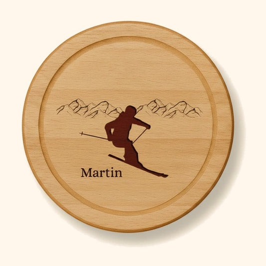 holzbrett personalisiert buche rund ski vor cremefarbenem Hintergrund.