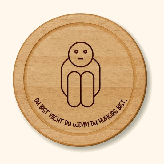 holzbrett personalisiert du bist nicht du buche rund vor cremefarbenem Hintergrund.
