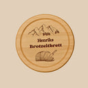 Rundes Brotzeitbrett aus Buchenholz mit personalisierter Gravur, Bergmotiv und Name im alpinen Stil.