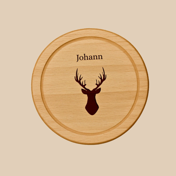 Rundes Holzbrett aus Buche mit personalisierter Gravur eines Hirschkopfes und dem Namen Johann.