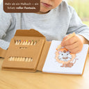 Kinder-Malbuch-Set mit 12 bunten Stiften in Kartonbox und aufgeschlagener Loewenmotiv-Seite zum Ausmalen.
