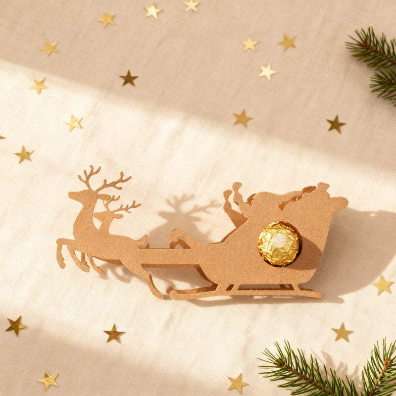 Rentier-Schlitten aus Holz als Schokoladenhalter mit goldener Praline, weihnachtliche Tischdeko zum Verschenken.