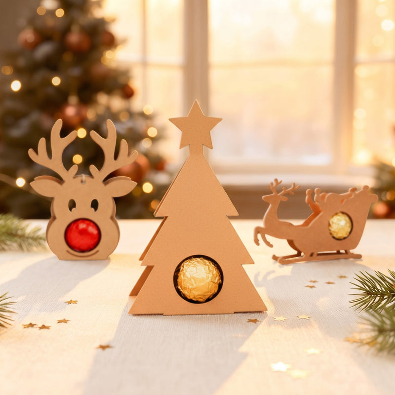 Weihnachtsbaum Schokoladenhalter mit Praline neben Rentier und weiteren Motiven auf weihnachtlichem Tisch