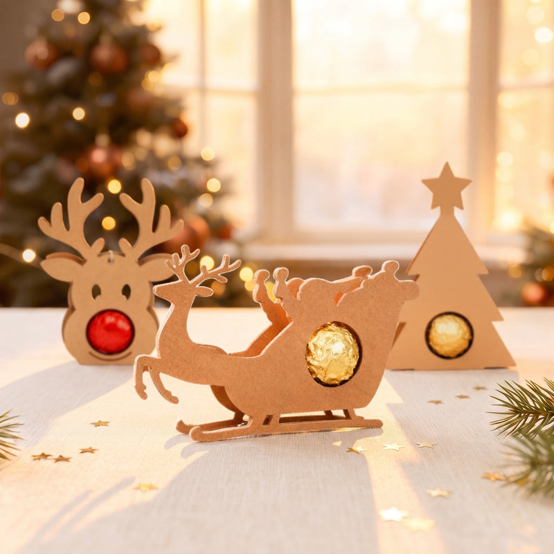 Rentier-Schlitten Schokoladenhalter mit Praline neben Rentier und weiteren Motiven auf weihnachtlichem Tisch