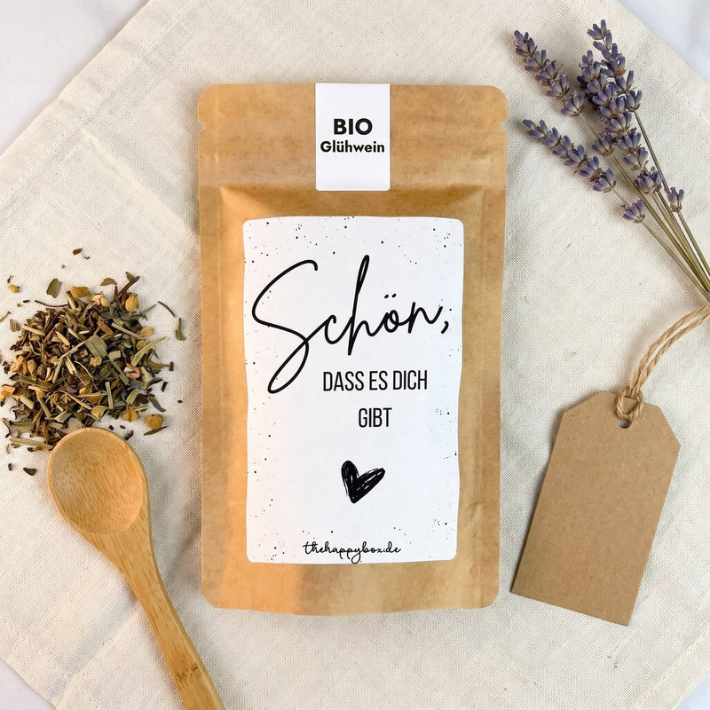 Sprüche-Tütchen von oben auf Leinen mit losem Tee, Holzlöffel, Lavendel und Kraftpapier-Anhänger.