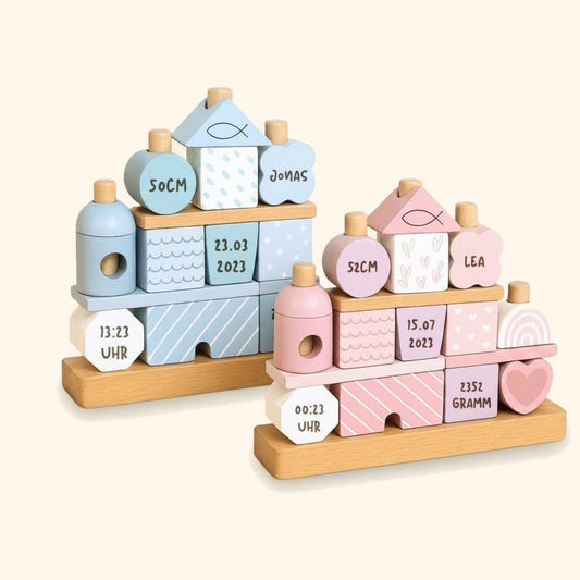 Stapelhaus Holz - Rosa/Blau vor cremefarbenem Hintergrund.