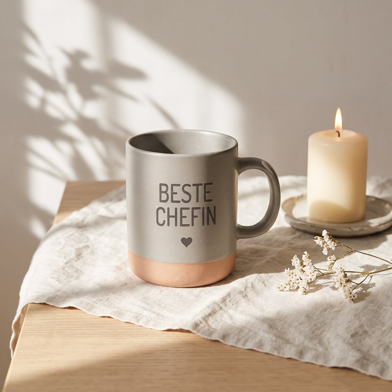 Keramik Tasse 360ml - Beste in grau: beste chefin, auf Leinen mit Kerze und Trockenblumen.