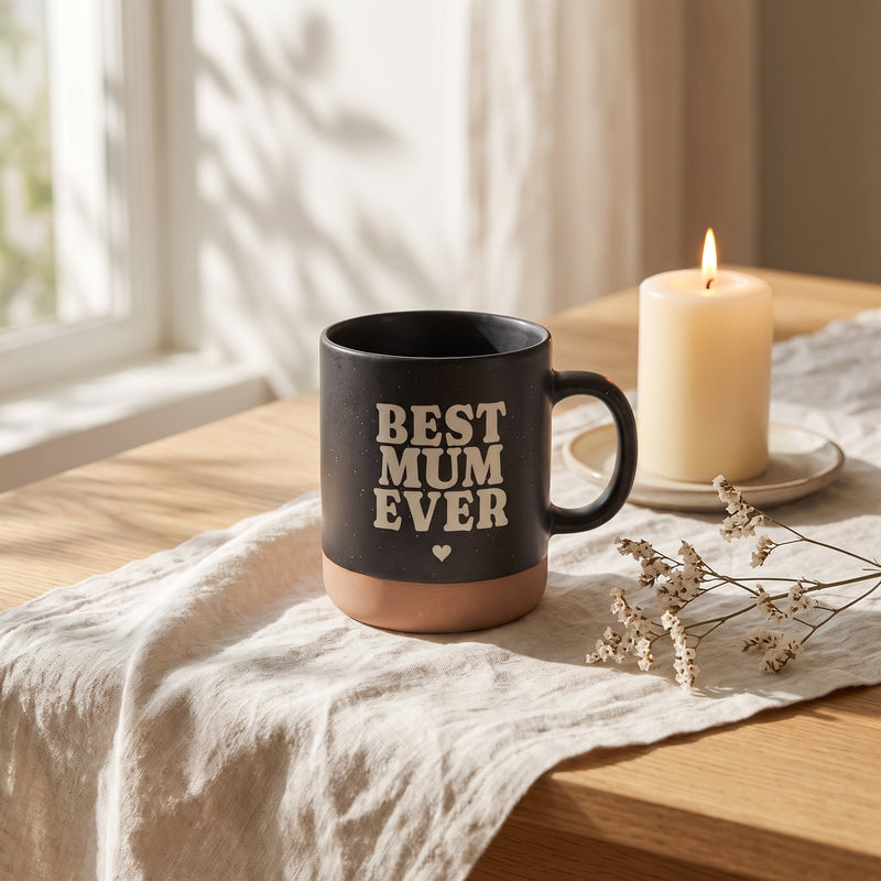 Keramik Tasse 360ml - Hot Mums Club in schwarz: best mum ever, auf Leinen mit Kerze und Trockenblumen.