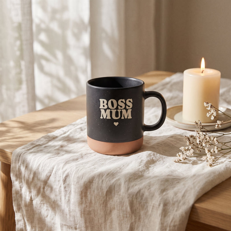 Keramik Tasse 360ml - Hot Mums Club in schwarz: boss mum, auf Leinen mit Kerze und Trockenblumen.