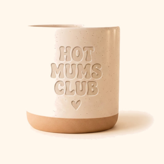 Keramik Tasse mit Ton-in-Ton-Gravur Hot Mums Club vor cremefarbenem Hintergrund.