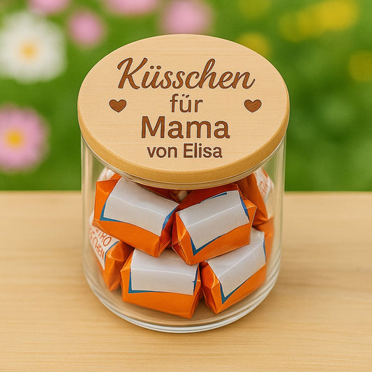 Vorratsglas mit graviertem Holzdeckel gefuellt mit Schokoladenkuesschen als personalisiertes Geschenk fuer Mama.