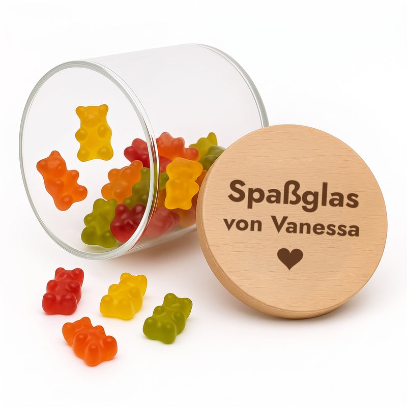 Liegendes Vorratsglas mit Gummibärchen, daneben der gravierte Buchenholzdeckel „Spaßglas von Vanessa“ mit Herz.