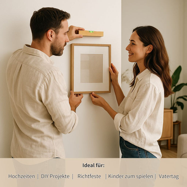 Paar haengt Bilderrahmen mit personalisierter Wasserwaage aus Buchenholz an die Wand, ideales Vatertagsgeschenk.