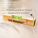 Personalisierte Wasserwaage aus Buchenholz mit graviertem Wunschtext, Namen und Herzen als Geschenkidee.