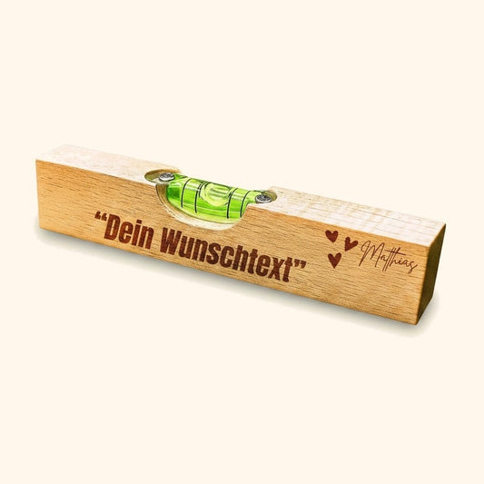 wasserwaage personalisiert buche gravur vor cremefarbenem Hintergrund.